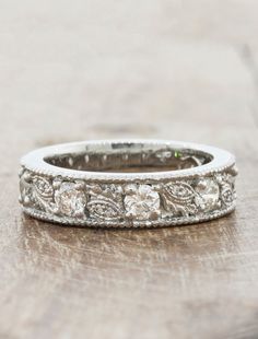 an antique diamond wedding ring on a wooden surface