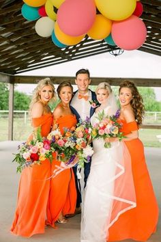 the bride and groom are posing with their bridal party friends in front of balloons