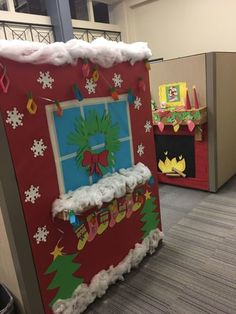 an office cubicle decorated for christmas with decorations on the front door and windows in the back