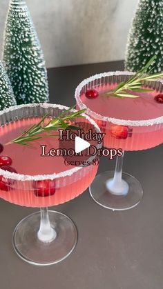 two glasses filled with pink liquid and garnished with cranberry on the rim