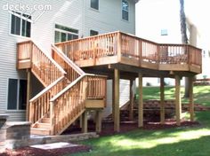 a wooden deck and stairs in front of a house