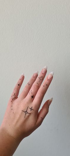 a woman's hand with tattoos on it and her fingers in the shape of an airplane