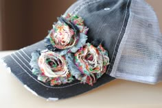 a hat with flowers on it sitting on top of a table