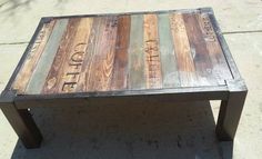 a bench made out of pallet wood with writing on the bottom and side tables