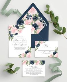 wedding stationery with flowers and greenery on the front, in navy blue envelope