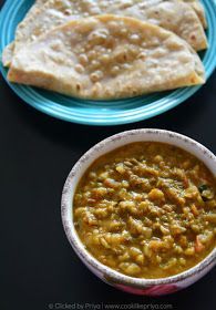 two plates filled with food next to each other on a black counter top and one plate has pita bread