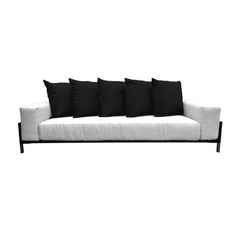 black and white couch with five pillows on it's back end, against a white background