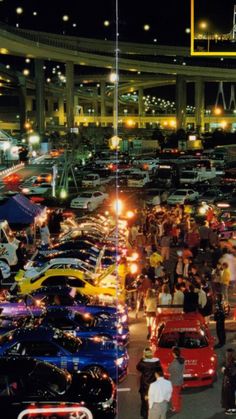 there are many cars that are parked in the parking lot at night and on the street