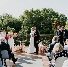 a bride and groom are standing at the end of their wedding ceremony as guests look on