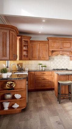 a large kitchen with wooden cabinets and counter tops is pictured in this image, there are stools at the center of the island