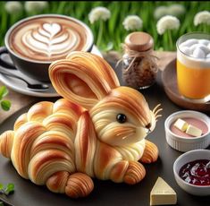 a sculpture of a bunny sitting on top of a table next to cups and saucers