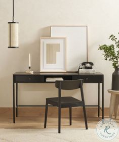 a desk with a chair, lamp and pictures on the wall in front of it