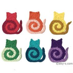 six crocheted cats sitting next to each other on top of a white surface