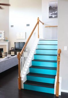 a living room filled with furniture and blue stairs