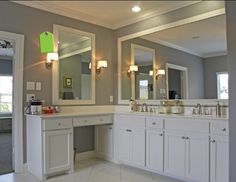 a large bathroom with double sinks, mirrors and lights on the ceiling is shown in this image