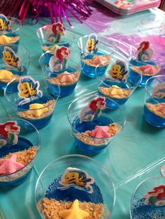 the little mermaid party food is ready to be eaten at the birthday party, including rice krispy treats and cupcakes