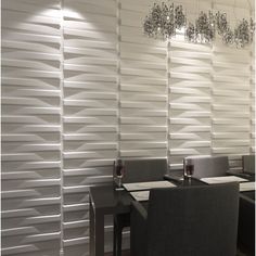 a dining room table and chairs in front of a white wall with vertical slats