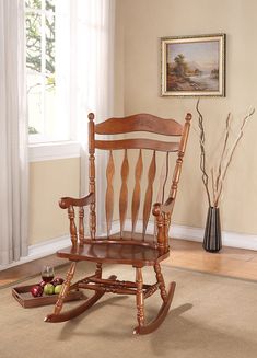 a wooden rocking chair sitting on top of a carpeted floor next to a window