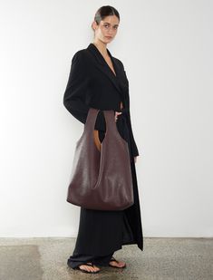 The Reversible Suede / Leather Sack is crafted from two single pieces of material, offering a minimalist design that mixes materials and texture to enforce a new take on modern craftsmanship. This hobo-style shoulder bag features a soft, unstructured form and no hardware, easily converting between natural suede and burgundy grain leather. Its oversized silhouette provides ample space and softens with use, making it ideal as a large day bag and travel bag. Carry over the shoulder, on the arm, or Versatile Textured Leather Shoulder Bag For Work, Everyday Structured Shoulder Bag With Smooth Grain, Smooth Grain Hobo Bag Tote For Work, Smooth Grain Hobo Bag In Tote Shape For Work, Smooth Grain Tote Hobo Bag For Work, Structured Hobo Bag For Everyday Use, Versatile Business Hobo Tote Bag, Minimalist Hobo Bag With Removable Pouch For Work, Textured Leather Hobo Shoulder Bag For Work