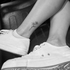 a woman's foot with a small flower tattoo on her left side calfocks