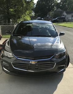 a black car parked in front of a house