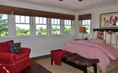 a bedroom with white walls and red furniture