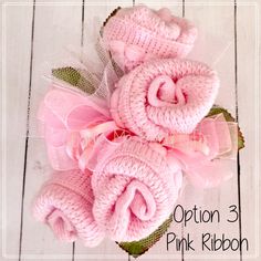 two pink knitted flowers on top of each other with the words cuddle mobby gifts