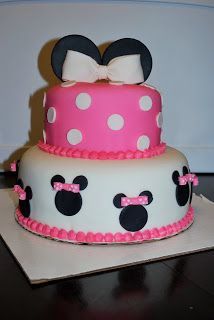 a pink and white cake decorated with minnie mouse ears