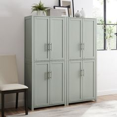 a room with a white chair and some green cabinets