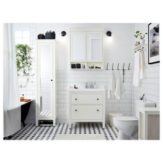 a white bathroom with black and white checkered flooring on the walls, sink, toilet and mirror