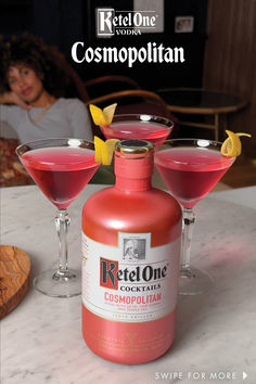 a bottle of red one cocktail next to two glasses filled with pink liquid on a table