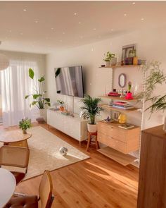 a living room filled with furniture and a flat screen tv on top of a wooden table