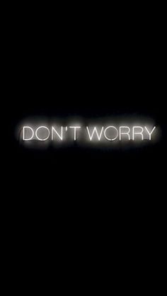 the words don't worry are lit up against a black background with white lettering