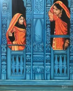 two women standing in front of a blue wall with ornate designs on it and one woman looking out the window