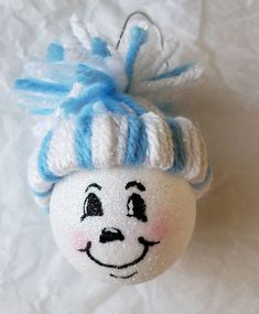 a white ornament with a blue and white hat on it's head