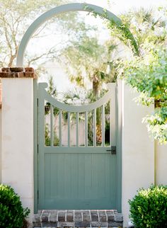 an open gate with a brick pathway leading to it