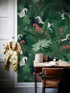 a room with a table, chair and wallpaper that has various animals on it