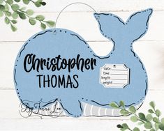 a blue whale with the words christopher thomas on it's back and some leaves around it