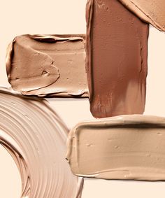 various shades of liquid foundation on a white background, including light beige and dark brown