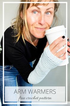 a woman is holding a coffee cup with her arm wrapped around her thumb and smiling