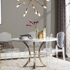 a dining room table with chairs and a chandelier hanging from the ceiling over it