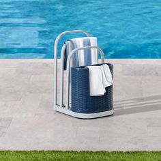 two towels are sitting on a towel rack next to the swimming pool with blue water in the background