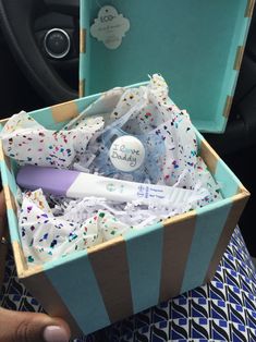 a person holding a box filled with personal care items and confetti on it