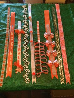 several ribbons and bows are laid out on a green tablecloth covered with plastic wrap