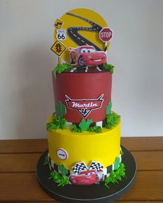 a three tiered cake with cars on it