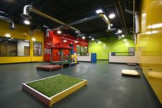 an indoor play area with artificial turf and yellow walls, green grass on the floor