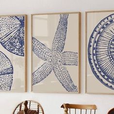 three blue and white art prints hanging on the wall