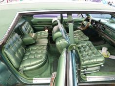 the interior of an old car with green leather seats and chrome rims on it