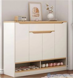 a white cabinet with some shoes on top of it