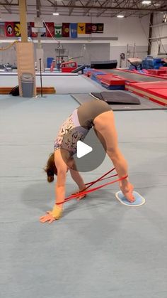 a woman is doing a handstand on a rope